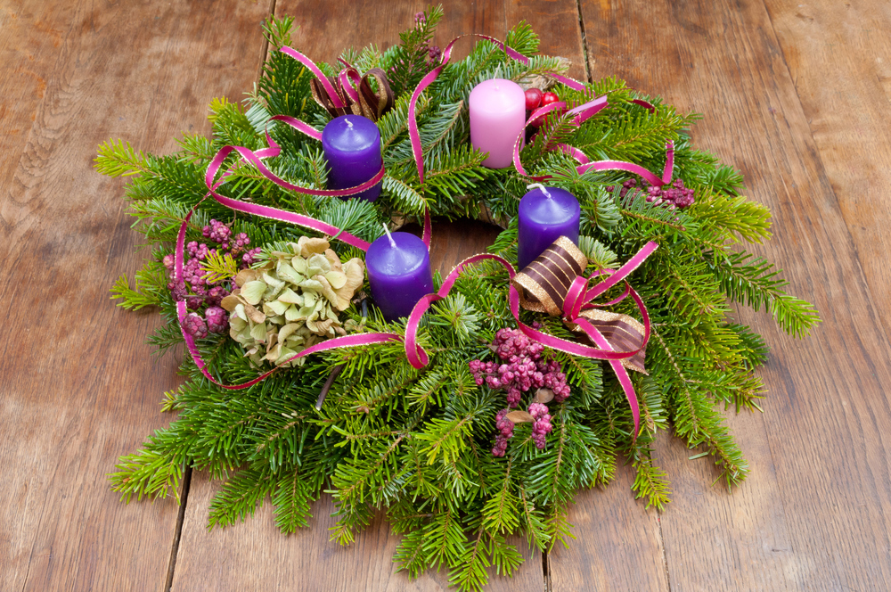 Adventkranz mit 3 Violetten und einer rose Kerze. / iStock/SzabolcsKiss Adventkranz mit 3 Violetten und einer rose Kerze.