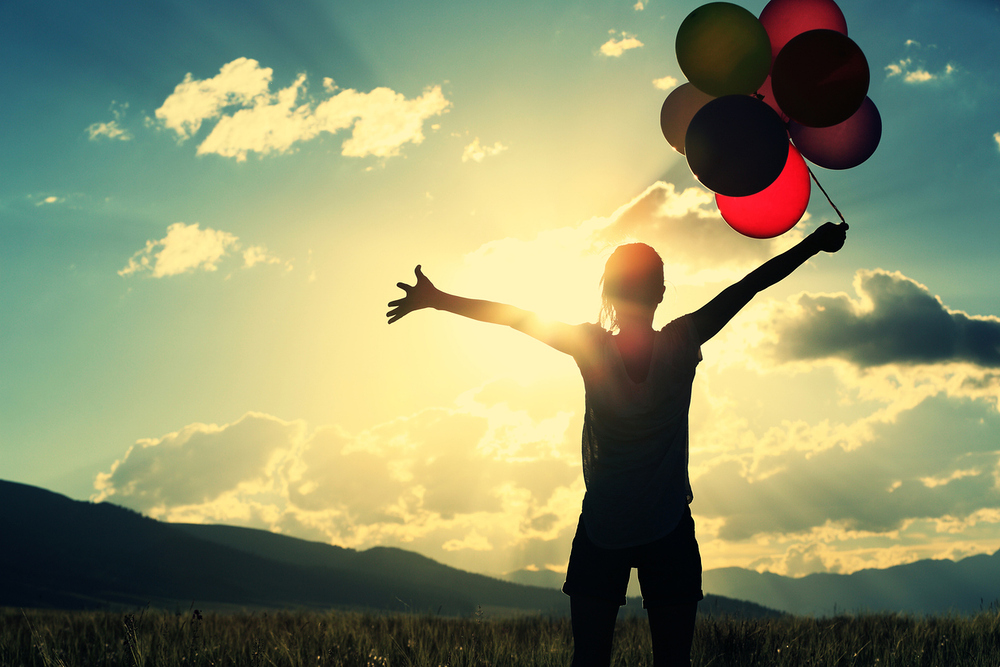 cheering young asian woman on sunset grassland with colored balloons / lzf cheering young asian woman on sunset grassland with colored balloons